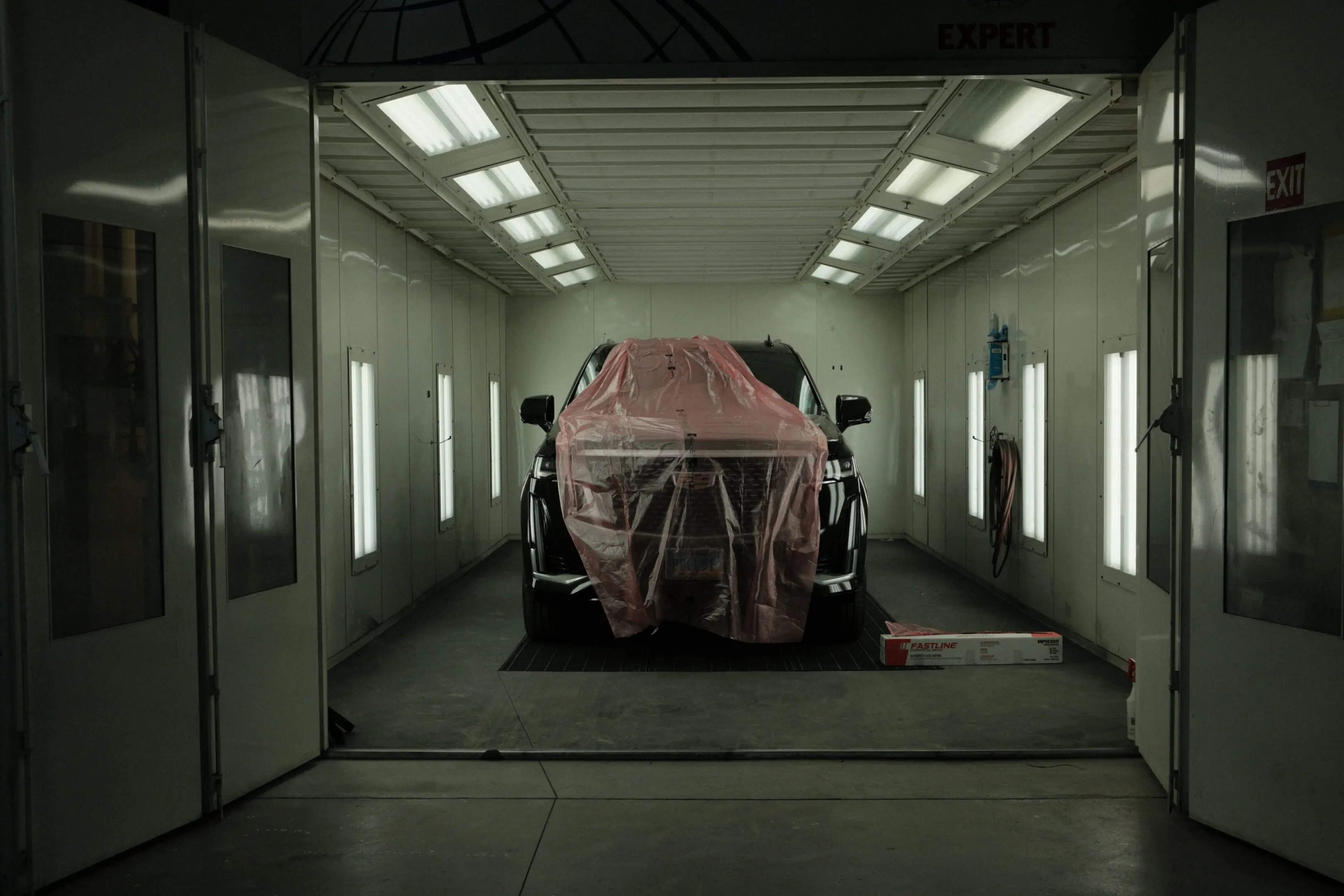 A car in the garage with its cover up.
